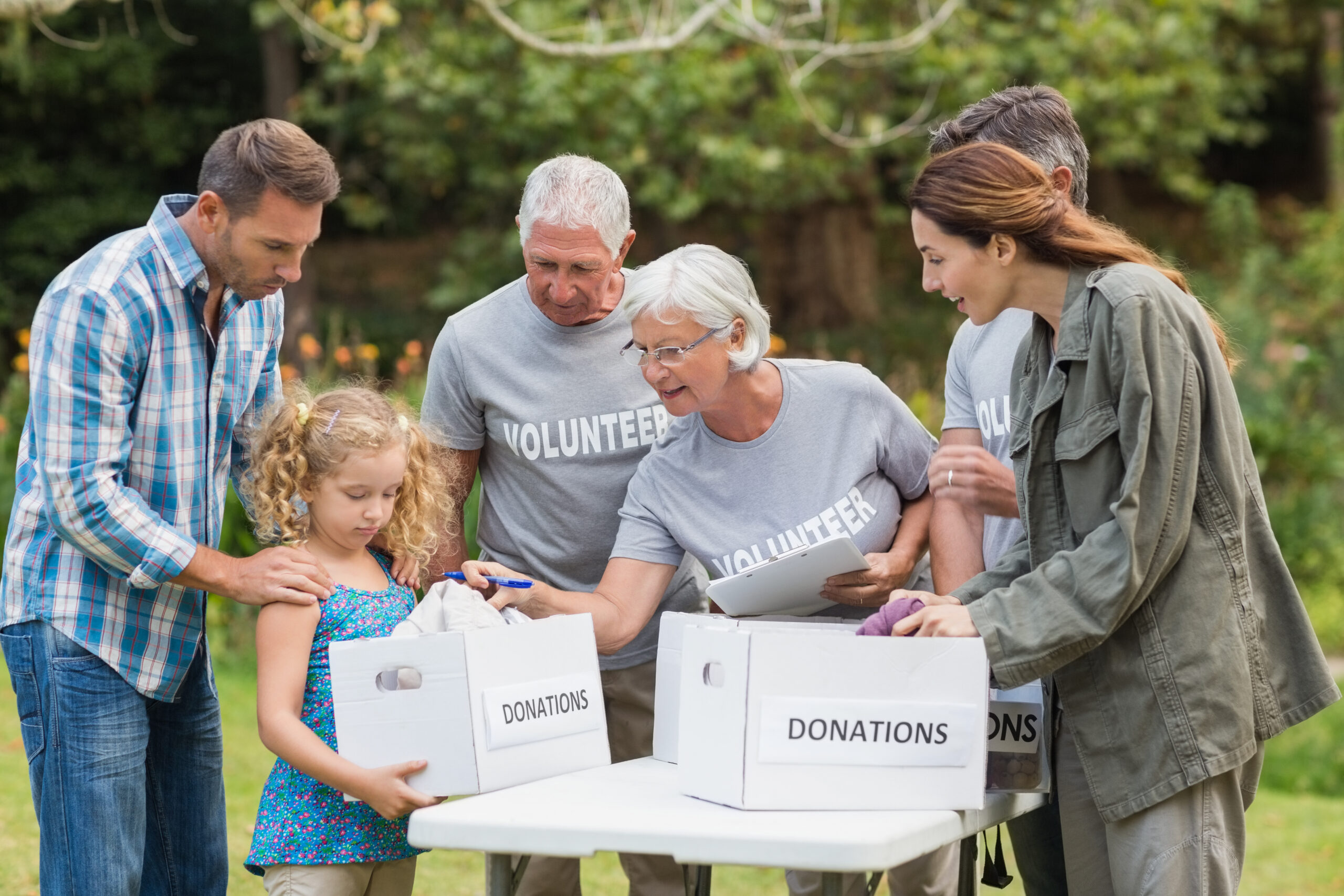 Happy volunteer family separating donations stuffs on a sunny day