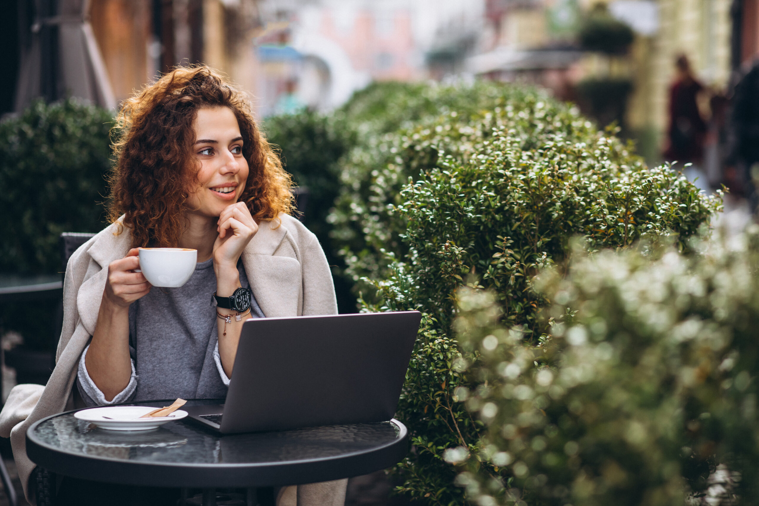 Young business woman working on a computer outside the cafe